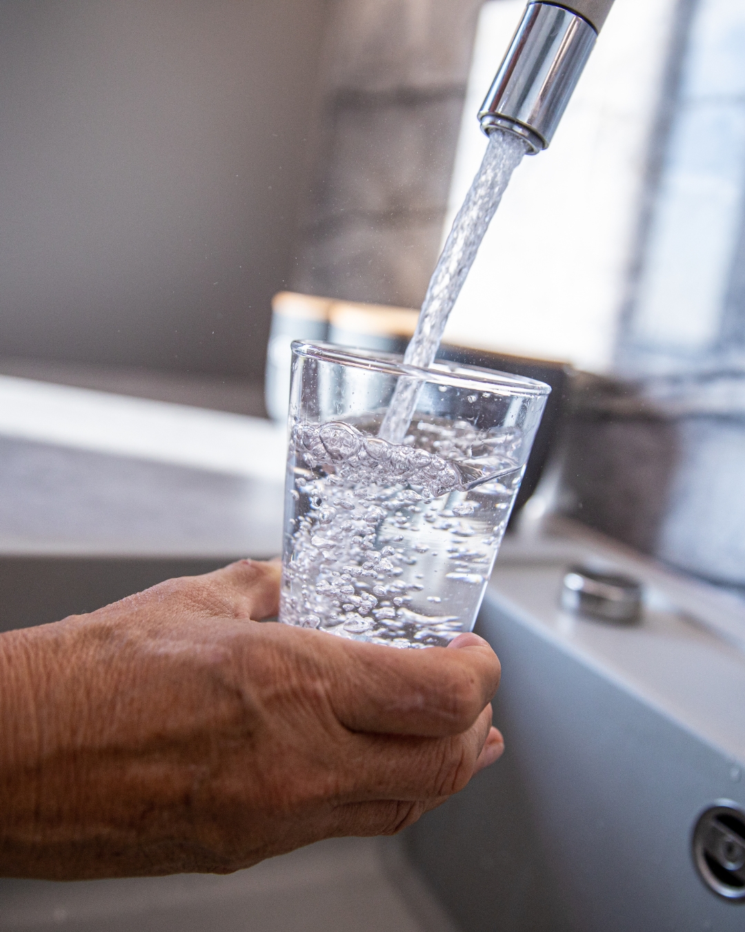 clean fresh water after filter installed Clean filtered drinking water poured from kitchen faucet after professional installation.